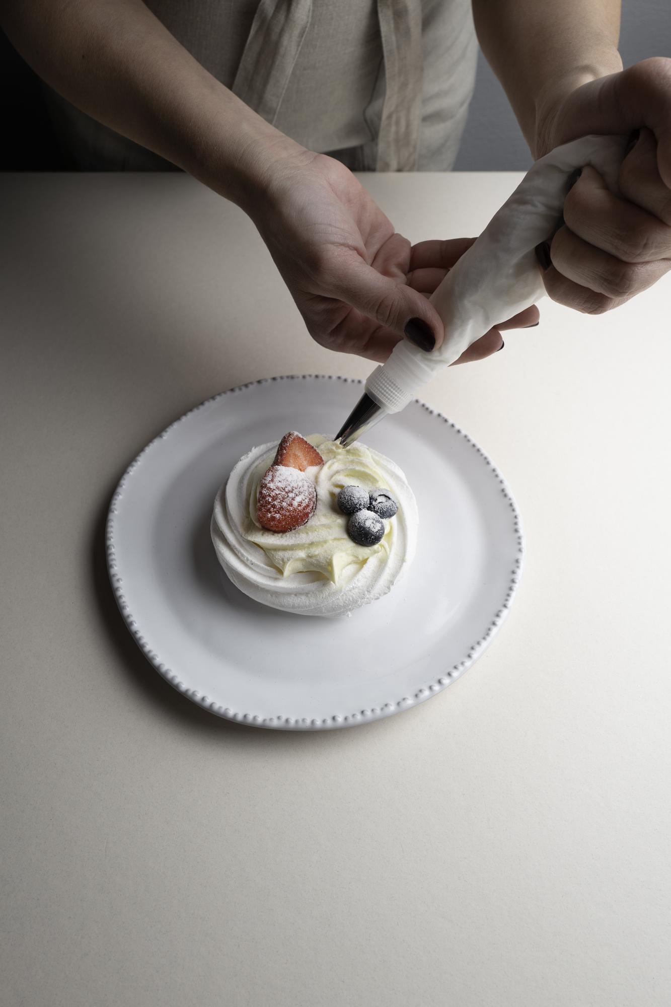 Hands plating a dessert during a workshop